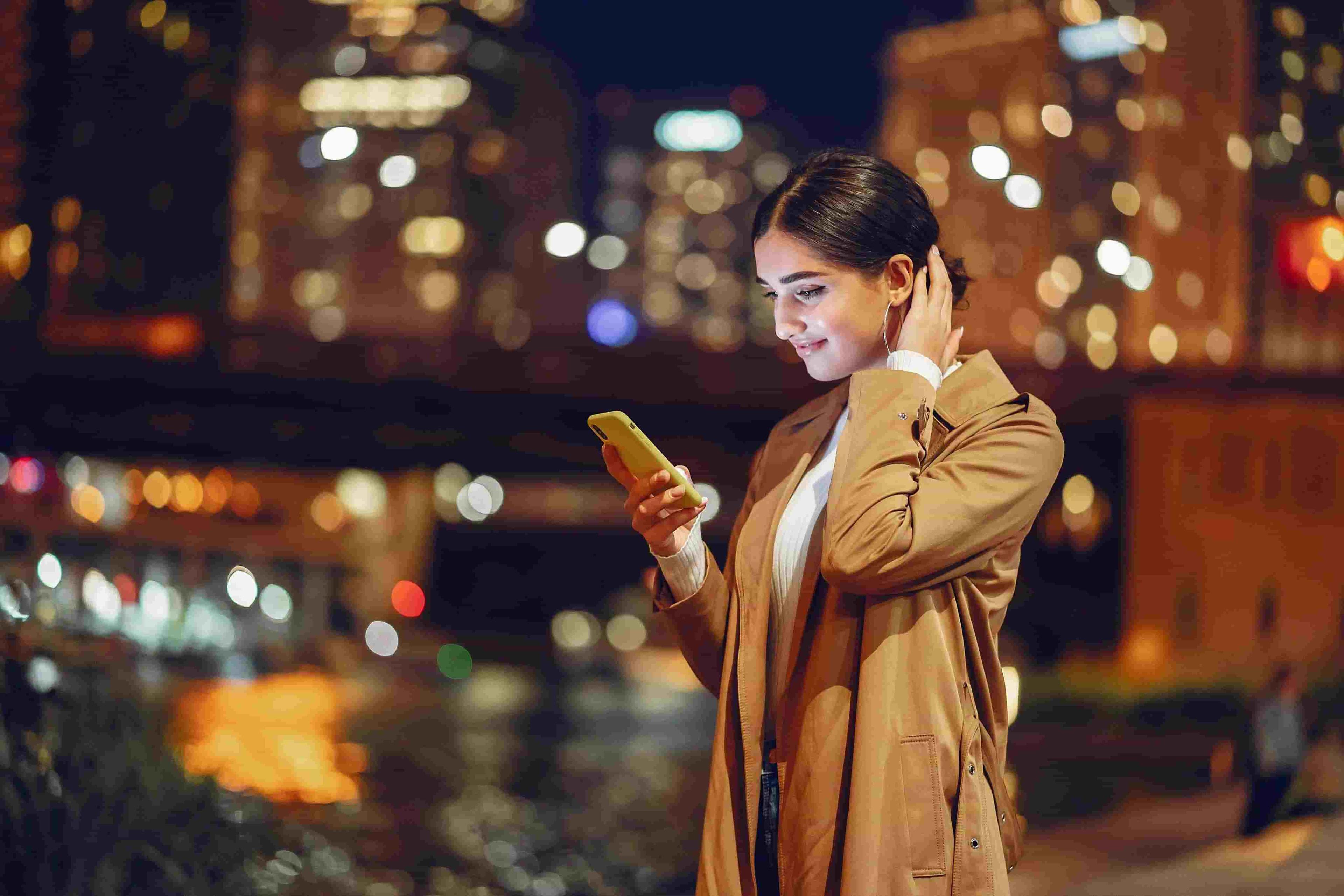 A woman using her phone with cracked screen
